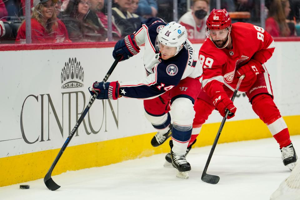 Columbus Blue Jackets center Gustav Nyquist (14) reaches for the puck against Detroit Red Wings center Sam Gagner (89) during the first period at Little Caesars Arena.