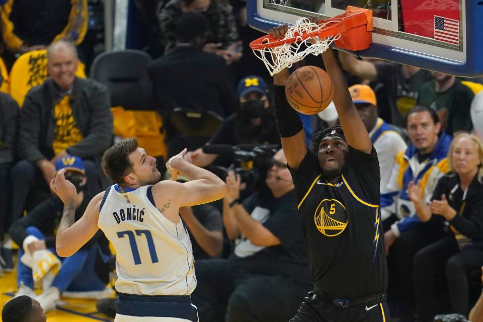 Golden State Warriors center Kevon Looney (5) dunks against Dallas Mavericks guard Luka Doncic (77) during the first half of Game 1 of the NBA basketball playoffs Western Conference finals in San Francisco, Wednesday, May 18, 2022. (AP Photo/Jeff Chiu)