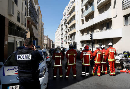 French firefighters secure the street as police conduct an investigation after two Frenchmen were arrested in Marseille, France, April 18, 2017 for planning to carry out an "imminent and violent attack" ahead of the first round of the presidential election on Sunday, France's interior minister said. REUTERS/Philippe Laurenson 