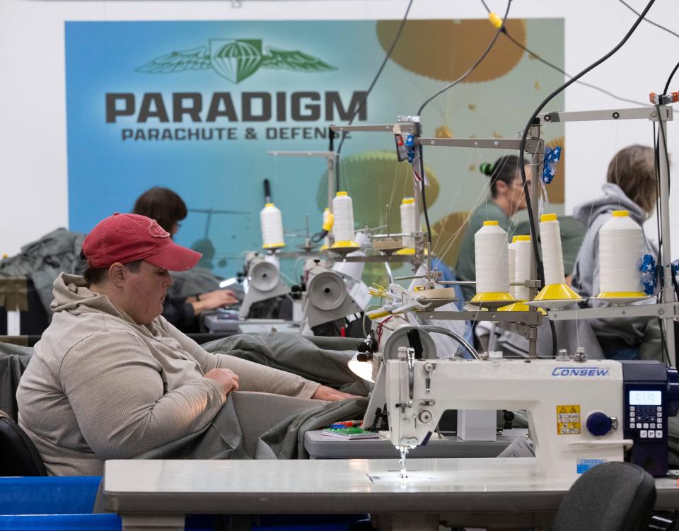 Paradigm Parachute and Defense employees work to complete parachutes for defense contractors at the company's facility in Escambia County on Nov. 7.