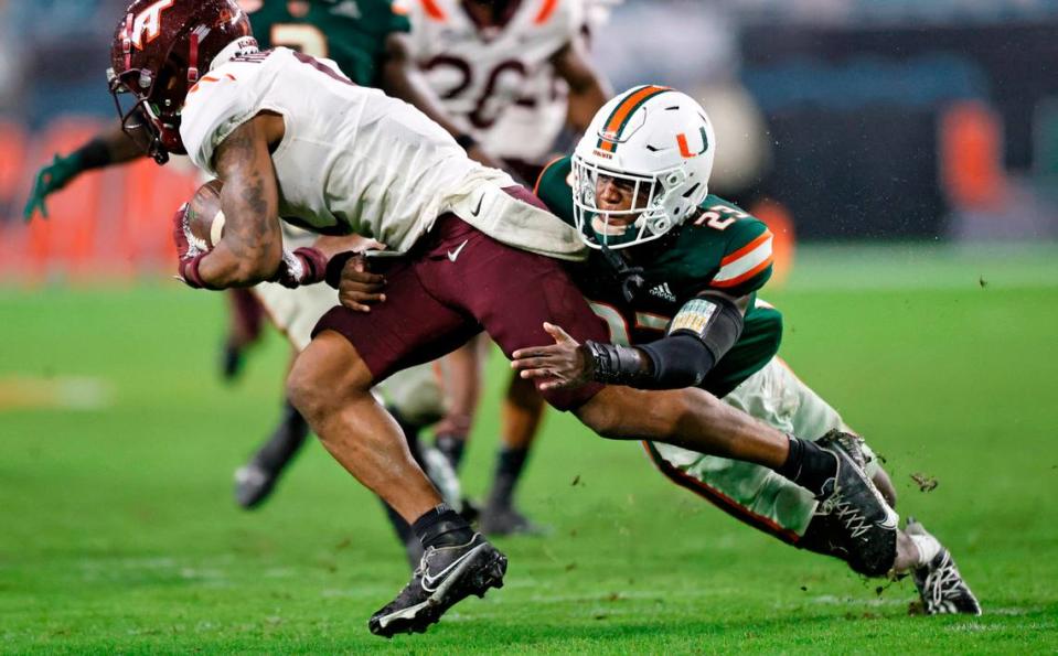 Miami Hurricanes cornerback Te’Cory Couch (23) tackle Virginia Tech Hokies wide receiver Tayvion Robinson (9) during the fourth quarter of their ACC football game at Hard Rock Stadium on Saturday, November 20, 2021 in Miami Gardens, Florida.