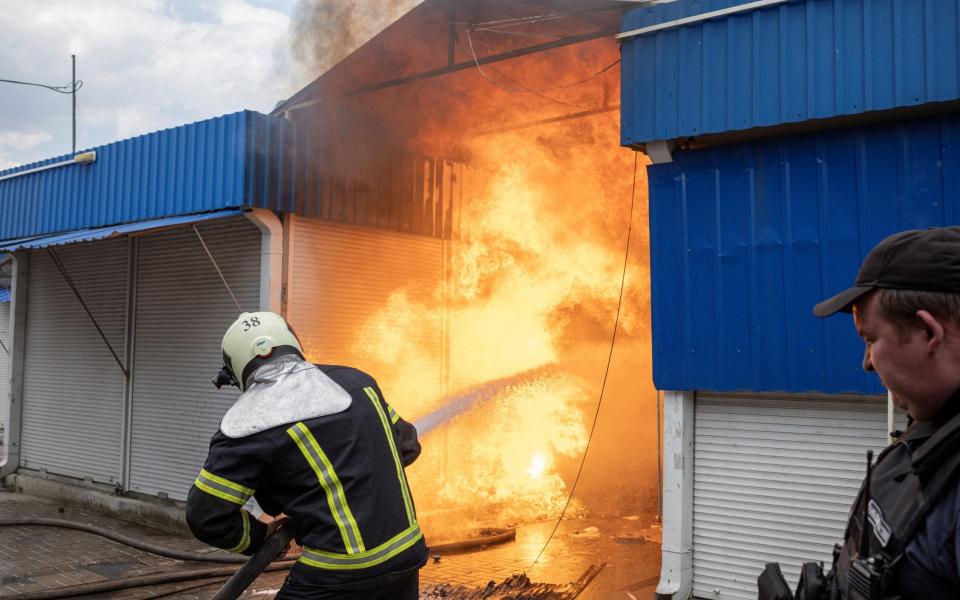 Firefighters spray water onto fire at the market after shelling, as Russia's attack on Ukraine continues, in Sloviansk, Donetsk region - Marko Djurica/Reuters