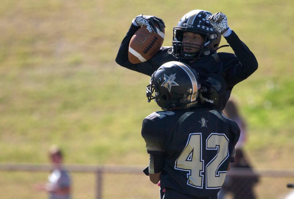 Plains' Fermin Luna (42) lifts Plains' Adrian Contreras after Contreras' touchdown against Smyer in a District 4-2A Division II football game, Thursday, Nov. 3, 2022, at Cowboy Stadium in Plains.