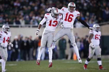 EAST LANSING, MI - NOVEMBER 8: Cam Burrows #16 and Eli Apple #13 of the Ohio State Buckeyes celebrate a defensive stop in the second half of the game against the Michigan State Spartans at Spartan Stadium on November 8, 2014 in East Lansing, Michigan. (Photo by Joe Robbins/Getty Images)