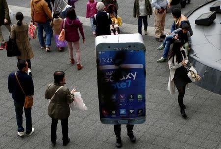A participant wearing costume symbolising Samsung Galaxy Note 7 walks among pedestrians after a Halloween parade in Kawasaki, south of Tokyo, Japan October 30, 2016. REUTERS/Kim Kyung-Hoon/Files