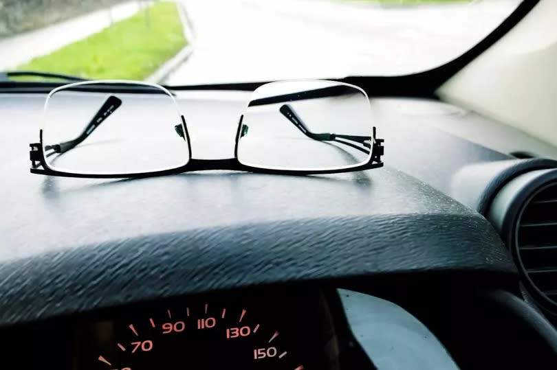 Glasses on car dashboard