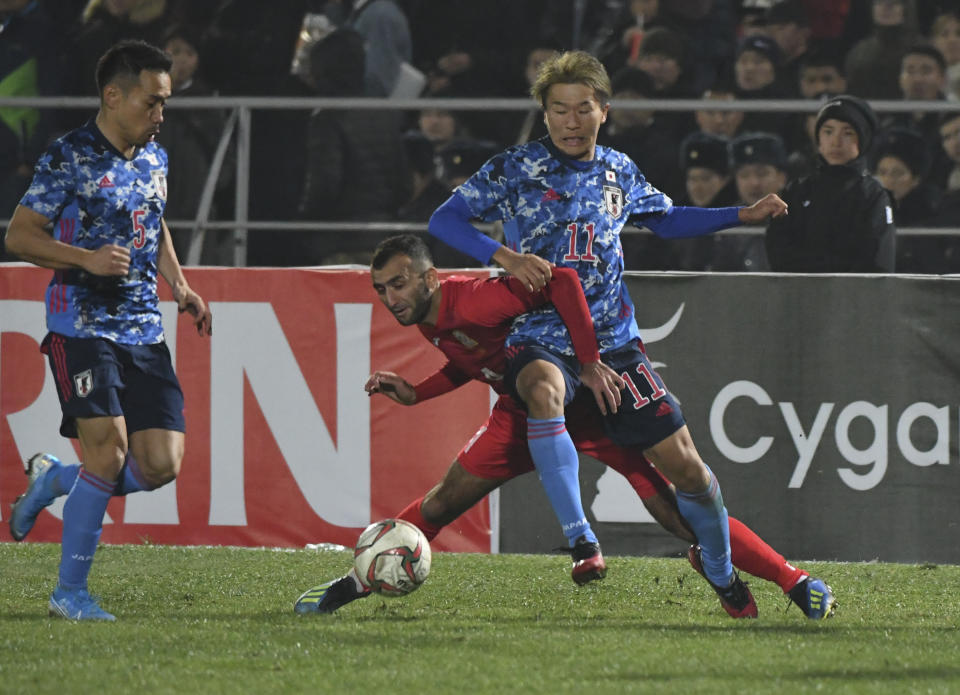 Japan's Nagai Kesuke, right, fights for the ball with Kyrgyzstan's Mustafa Iusupov during the World Cup 2022 Qualifying Asian zone Group F soccer match between Kyrgyzstan and Japan in Bishkek, Kyrgyzstan, Thursday, Nov. 14, 2019. (AP Photo/Vladimir Voronin)