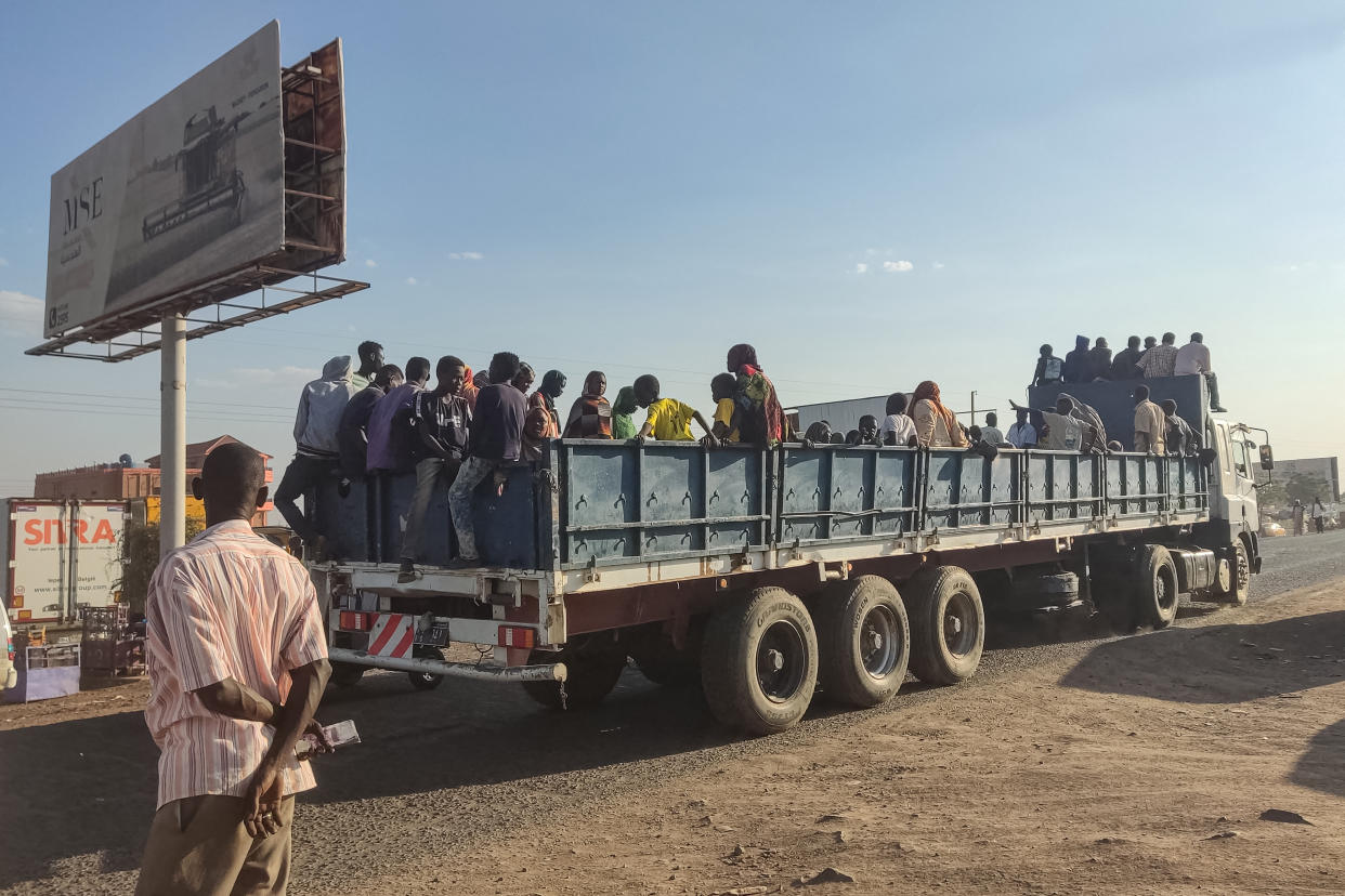 People displaced by the conflict in Sudan ride atop the back of a truck as they flee Wad Madani, the capital of al-Jazirah state, heading to Gadaref state on December 16, 2023. Fighting between the Sudanese army and paramilitaries engulfed the aid hub of Wad Madani on December 15, triggering an exodus of civilians already displaced by eight months of war, an AFP correspondent reported. (Photo by AFP) (Photo by -/AFP via Getty Images)