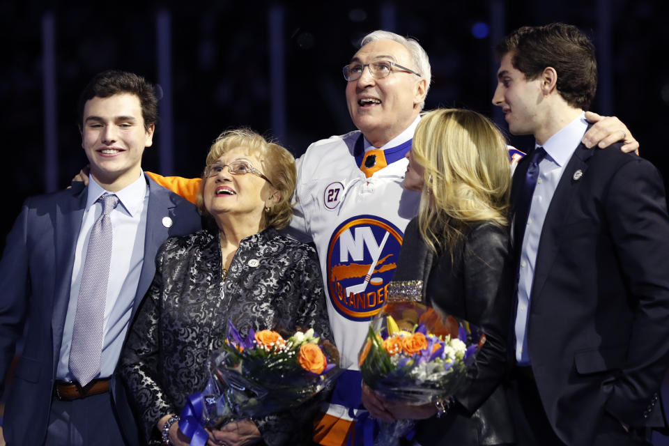 John Tonelli, center, who played for the New York Islanders during four Stanley Cup-championship seasons, stands with his mother, Joy; wife, Lauren; and sons Jordan and Zach as he watches while his jersey No. 27 is raised to the rafters Friday, Feb. 21, 2020, in Uniondale, N.Y. (AP Photo/Kathy Willens)