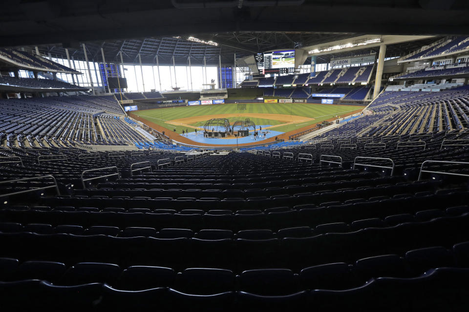 FILE - In this Thursday, July 16, 2020, file photo, the Miami Marlins take batting practice during a baseball workout at Marlins Park in Miami. The Marlins, one of the most under-the-radar teams in sports, have making news lately, all of it bad. Overtaken by a coronavirus outbreak, the team must scramble for roster replacements as they try salvage a season barely underway.(AP Photo/Wilfredo Lee, File)