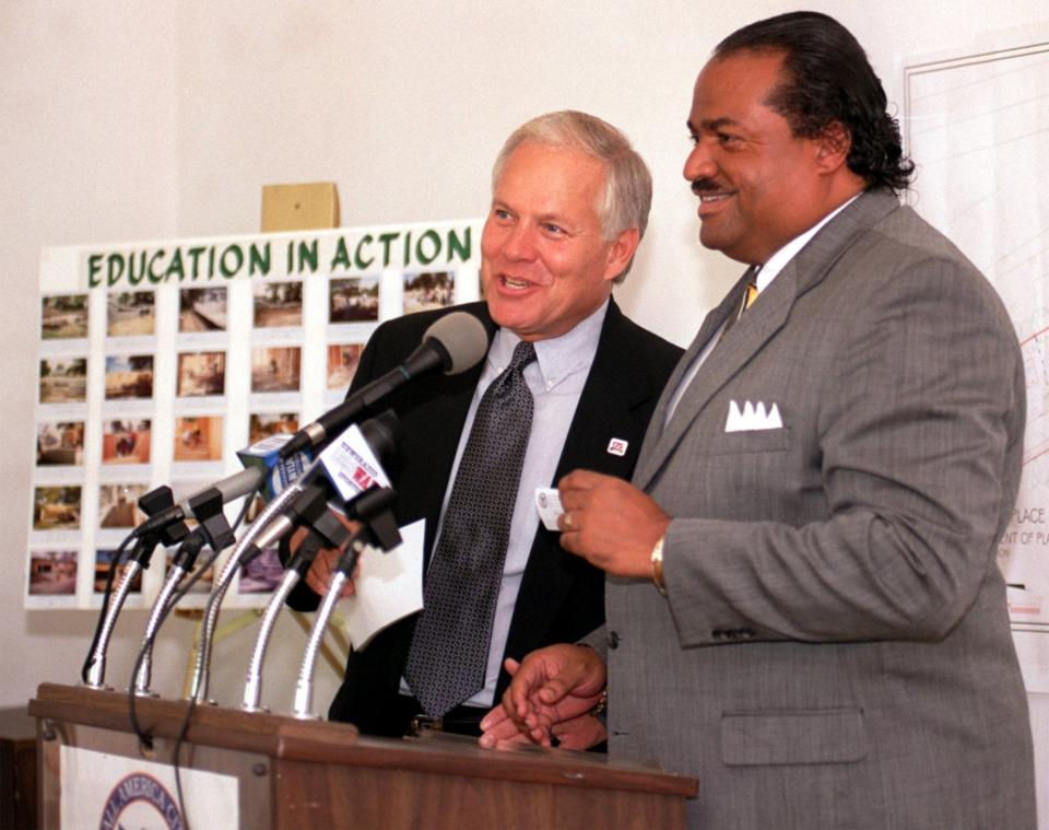 Mayor Don Plusquellic jokes with City Council President Marco Sommerville during a press conference in the new Akron subdivision Blake Place, named after the Rev. Col. William Blake, in July 2000.