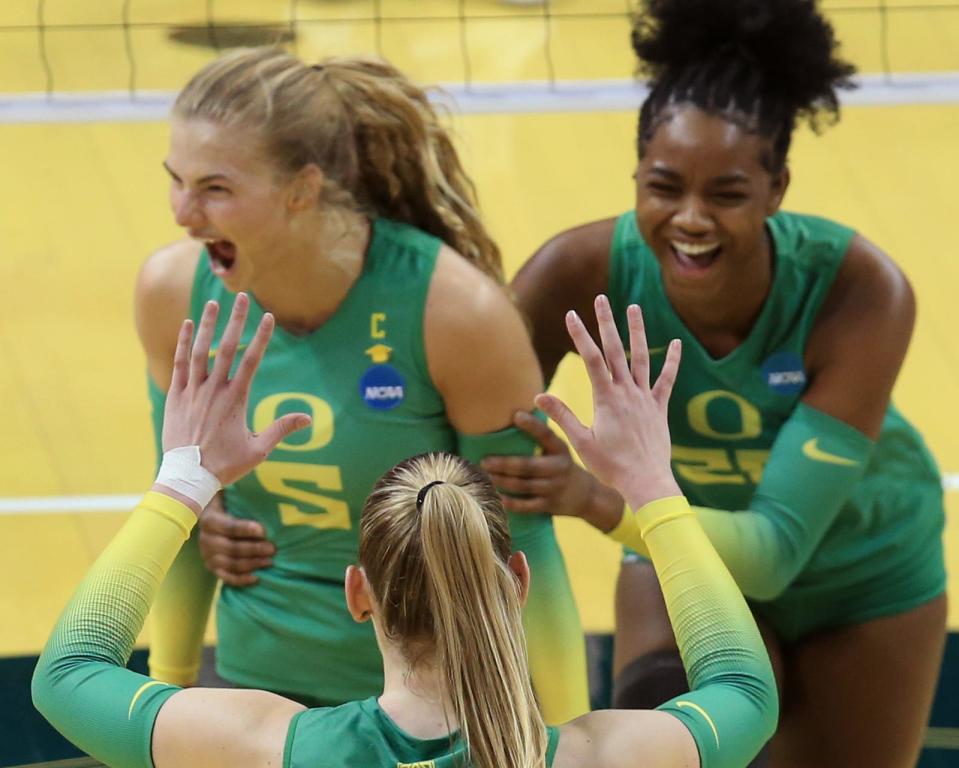 Oregon's Brooke Nuneviller, left, celebrates a point with teammates Mimi Colyer and Kiari Robey during the NCAA Round 2 match against Arkansas in Eugene on Saturday.