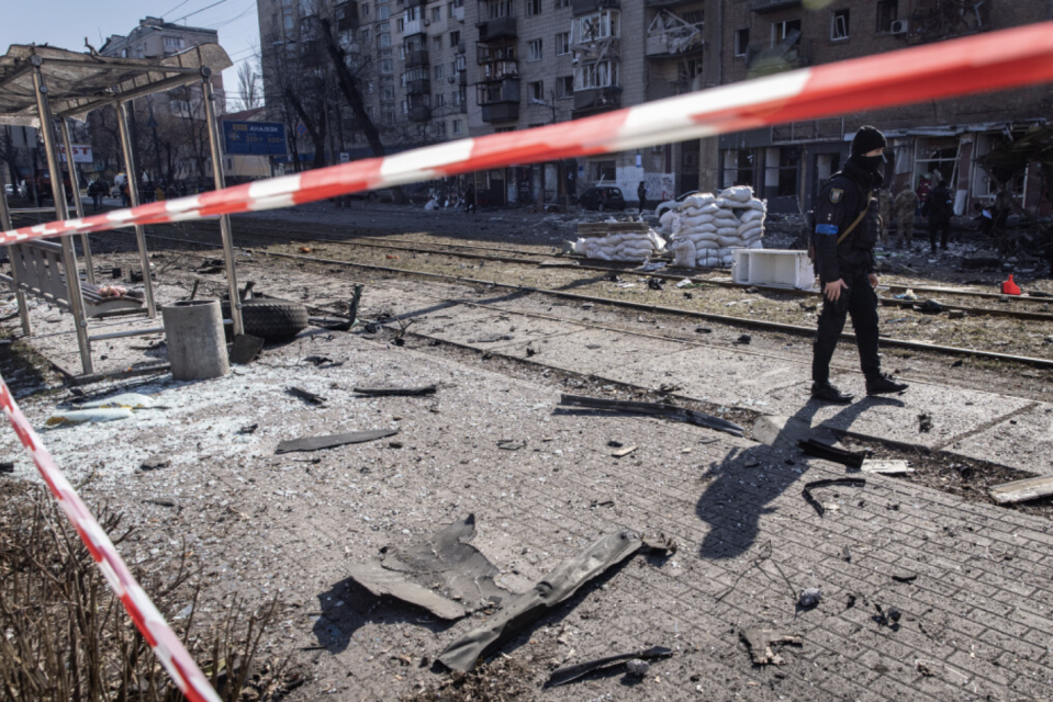 A member of the Ukrainian military stands amid the debris from a damaged residential apartment block caused after a Russian rocket was shot down by Ukrainian air defenses in Kyiv, Ukraine.