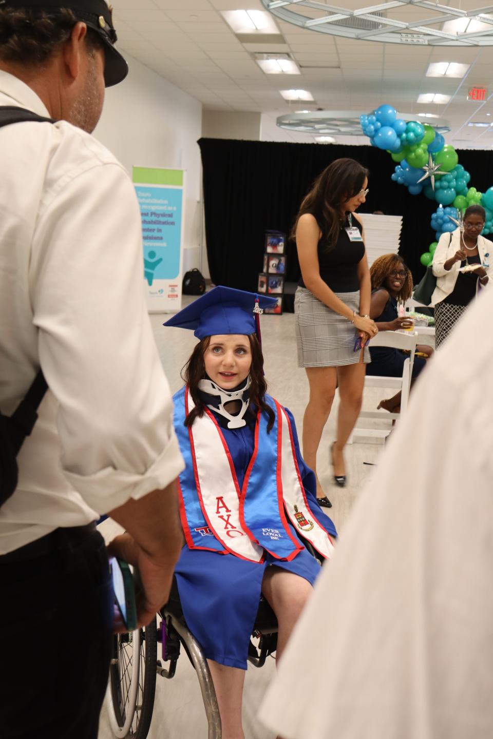 MacKenzie Maier talks to a member of the Refried Confuzion brass band June 23 after her graduation ceremony in New Orleans. The Louisiana Tech University graduate was seriously injured in a car crash, so she couldn't participate in the ceremony in Ruston.