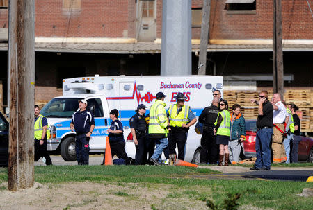 Firefighters and other officials congregate in an evacuated area where a chemical spill near a MGP Ingredients plant caused a toxic cloud that injured dozens of people and forced an evacuation in downtown Atchison, Kansas, U.S., October 21, 2016. REUTERS/Dave Kaup