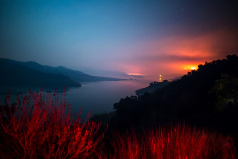 The Thomas Fire burns a hillside behind Lake Casitas in Ventura, California on December 8, 2017