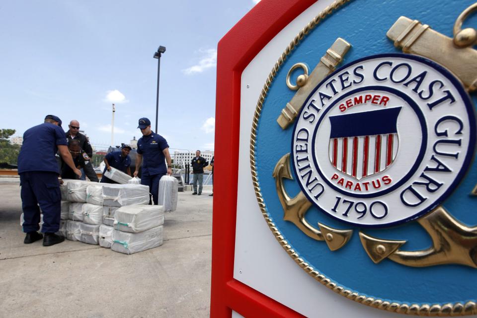 U.S. Coast Guards display part of the 1280 kg (2822 pounds) of cocaine, worth an estimated $37 million, seized in a routine patrol during a media presentation in San Juan, May 6, 2014. The U.S. Coast Guard seized the drugs on April 29 during an at-sea interdiction south of Puerto Rico and also arrested two traffickers from the Dominican Republic. REUTERS/Ana Martinez (PUERTO RICO - Tags: CRIME LAW DRUGS SOCIETY)