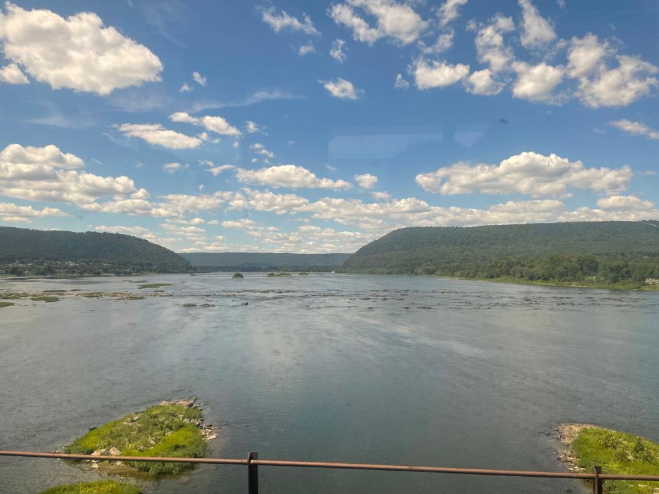 Views of mountains and a lake taken from a train window.