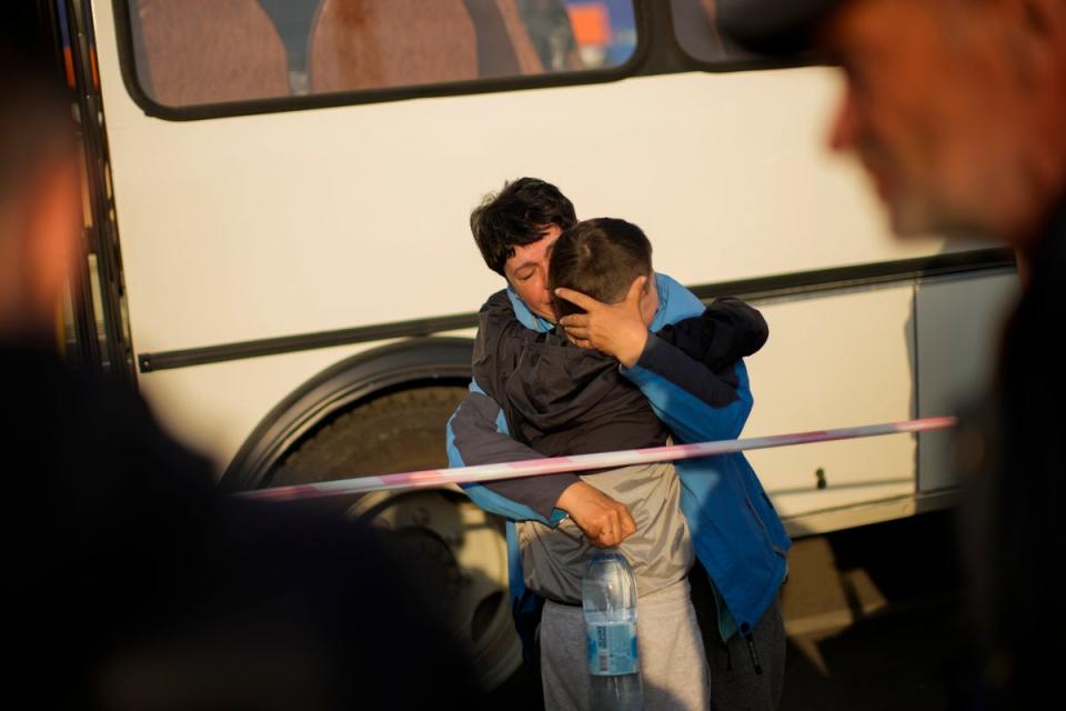 A woman hugs her grandson as she arrives in a bus with people who fled to a reception centre for displaced people in Zaporizhzhia (AP)