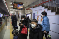 Passengers wear face masks as they wait for a train at a subway station in Beijing, Friday, Jan. 24, 2020. China broadened its unprecedented, open-ended lockdowns to encompass around 25 million people Friday to try to contain a deadly new virus that has sickened hundreds, though the measures' potential for success is uncertain. (AP Photo/Mark Schiefelbein)