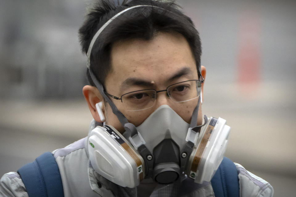 A man wears a respirator as he rides along a street in the central business district in Beijing, Tuesday, May 10, 2022. China's capital began another round of three days of mass testing for millions of its residents Tuesday in a bid to prevent an outbreak from growing to Shanghai proportions. (AP Photo/Mark Schiefelbein)