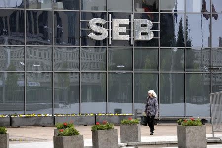 A woman walks past a SEB bank branch in Vilnius May 10, 2014. REUTERS/Ints Kalnins