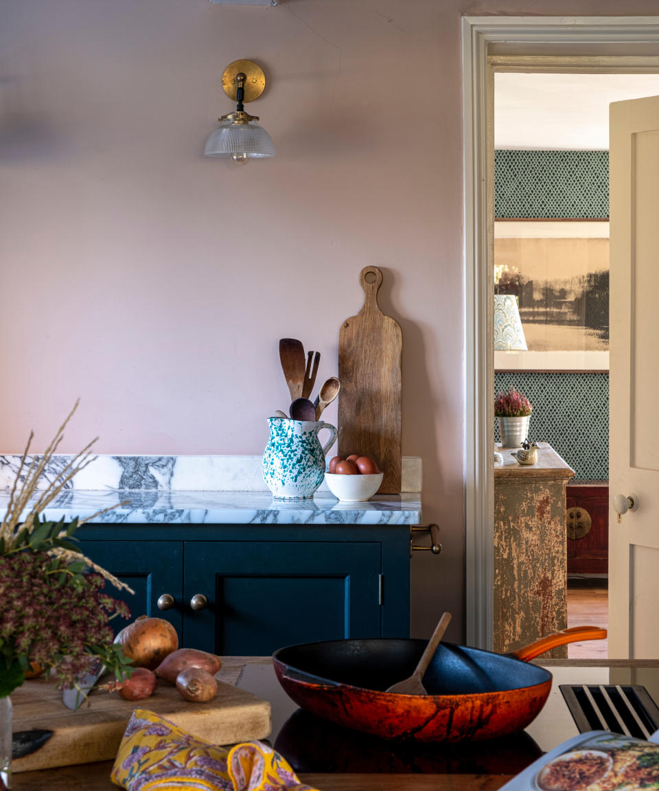 view from kitchen, with marble worktops and painted units, into hallway