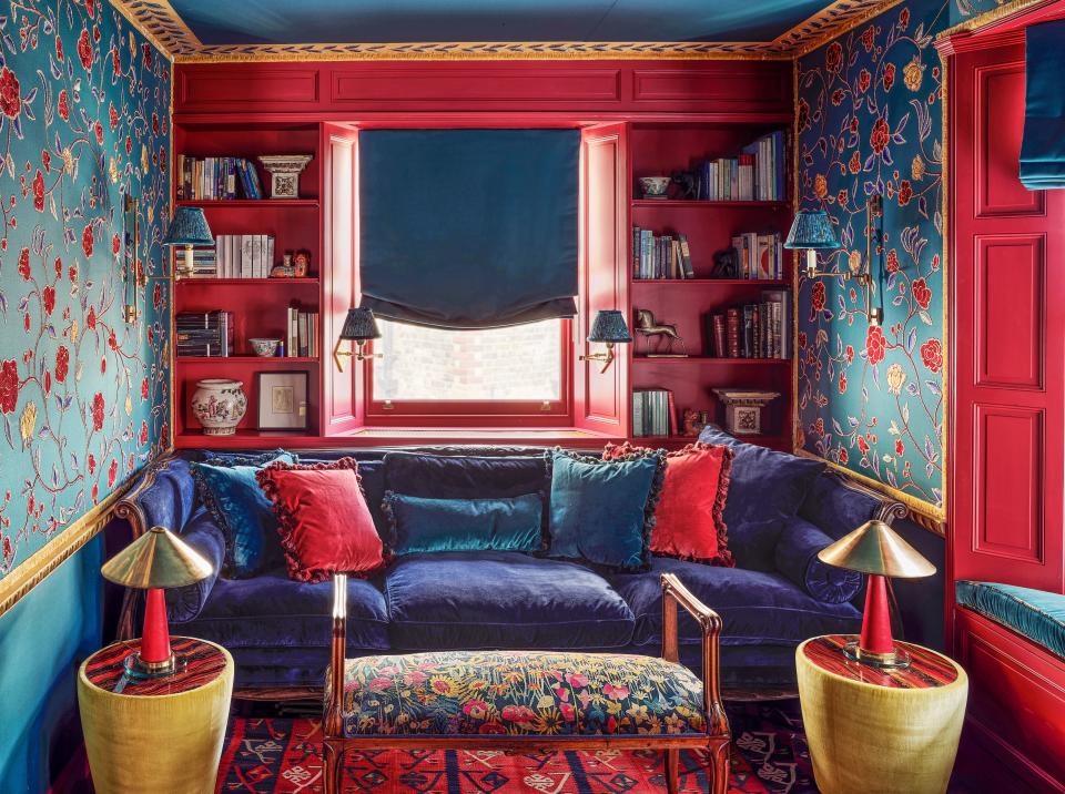 Pops of Benjamin Moore’s raspberry truffle paint accent the den. Floral wall covering and side tables by Alessandra Branca for de Gournay; Vaughan sconces; antique bench wears a Liberty Fabrics print.