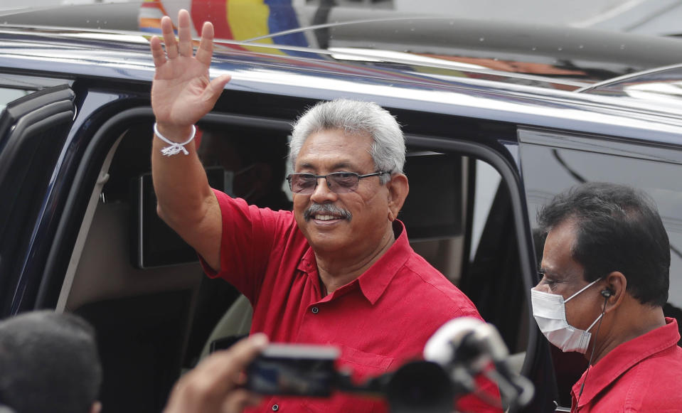 Sri Lankan President Gotabaya Rajapaksa waves as he leaves after casting his vote, outside a polling station in Colombo, Sri Lanka, Wednesday, Aug. 5, 2020. Sri Lankans started voting Wednesday to elect a new Parliament that is expected to give strong support to the powerful and popular Rajapaksa brothers. (AP Photo/Eranga Jayawardena)