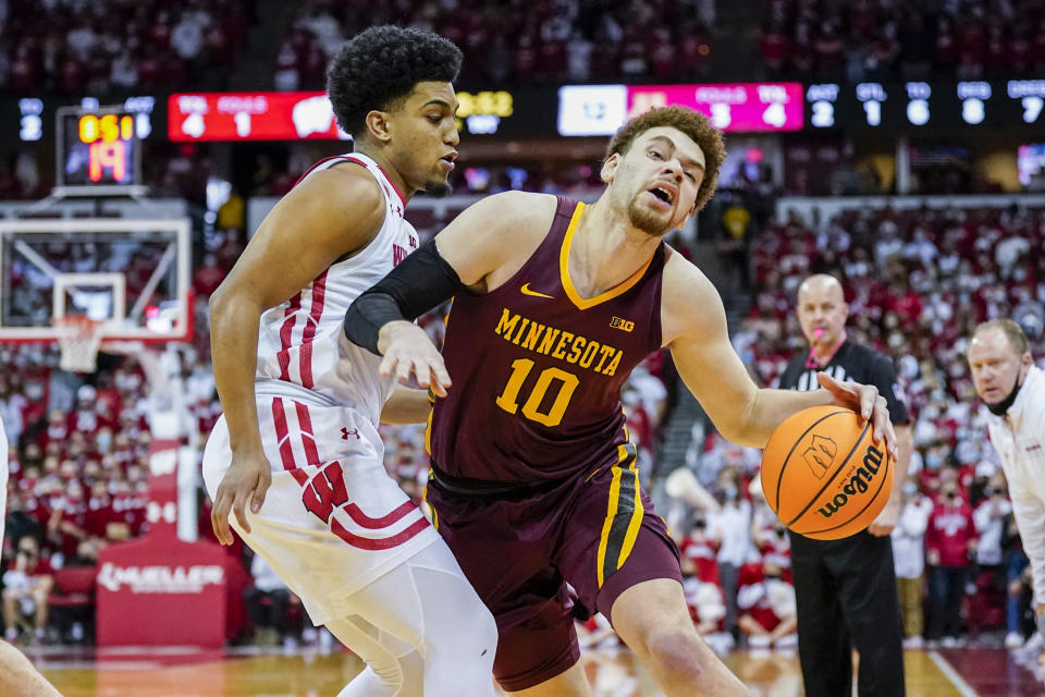 Minnesota's Jamison Battle (10) drives against Wisconsin's Chucky Hepburn (23) during the first half of an NCAA college basketball game Sunday, Jan. 30, 2022, in Madison, Wis. (AP Photo/Andy Manis)