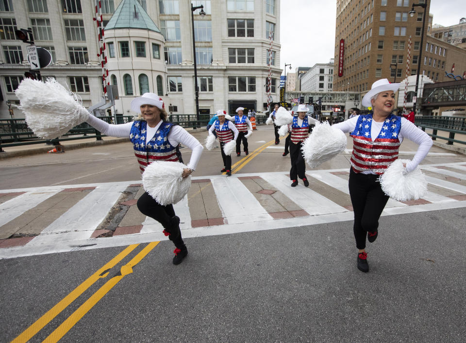 Colleen Minisce, left, and Janet Polley, right, and other members of the Milwaukee Dancing Grannies perform by at a Veterans’ Day parade on Saturday, Nov. 5, 2022, in Milwaukee. The Grannies have recently added several new members, including Minisce and Polley, as they’ve rebuilt after tragedy hit last year at a Christmas parade in Waukesha, Wis. Three Dancing Grannies and one group member’s husband were among those killed when the driver of an SUV struck them on the parade route. Dozens more, including some Grannies, were injured. (AP Photo/Kenny Yoo)