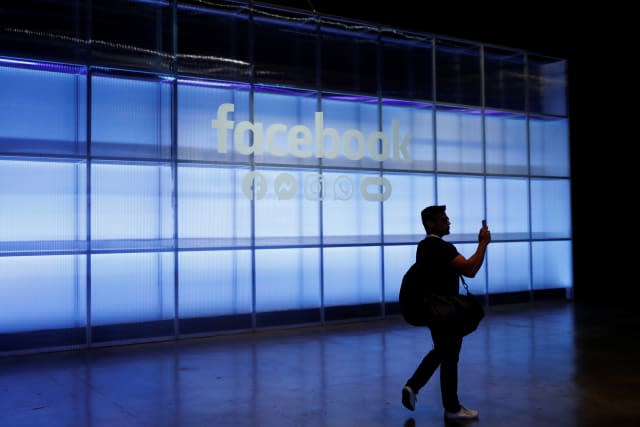 An attendee takes a photograph of a sign during Facebook Inc's F8 developers conference in San Jose, California, U.S., April 30, 2019.  REUTERS/Stephen Lam