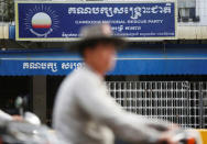 A man rides a motorcycle past the Cambodia National Rescue Party (CNRP) headquarters in Phnom Penh, Cambodia, November 17, 2017. REUTERS/Samrang Pring