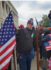 A photo from the Jan. 6, 2021 insurrection at the U.S. Capitol that the U.S. Department of Justice says shows Dustin B. Thompson of Columbus with a wooden coat rack he stole from inside the Senate wing.