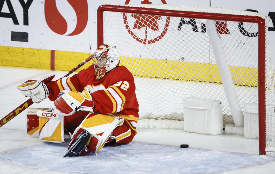 Calgary Flames goalie Dustin Wolf (32) reacts to letting in a goal by the Arizona Coyotes during the first period of an NHL hockey game in Calgary, Alberta, Sunday, April 14, 2024. (Jeff McIntosh/The Canadian Press via AP)