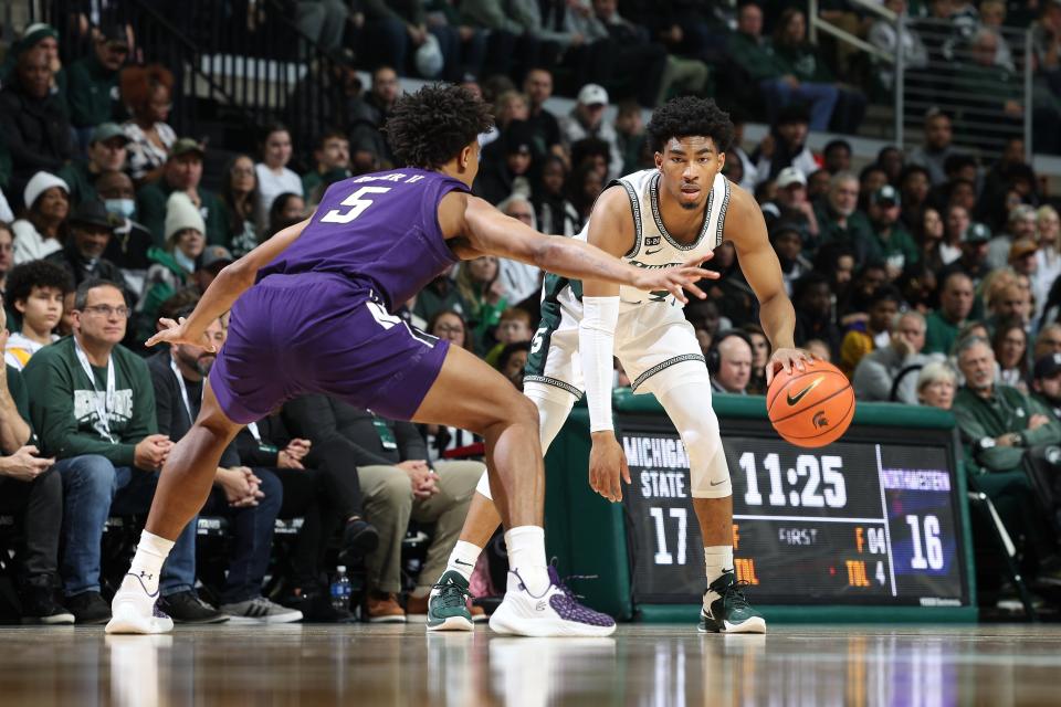 Jaden Akins (3) of the Michigan State Spartans handles the ball while defended by Julian Roper II (5) of the Northwestern Wildcats in the first half of the game at Breslin Center on December 4, 2022 in East Lansing, Michigan.