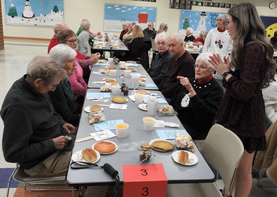 Brynn Waters takes drink orders for a table of senior citizens at a recent luncheon to honor the elders of the community at Ridgewood High School. About 120 senior citizens attended with 21 student council members helping to serve.