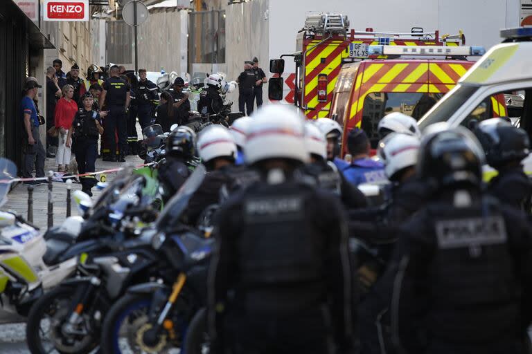 Agentes de policía y socorristas se reúnen cerca de la avenida de los Campos Elíseos, tras un apuñalamiento el jueves 18 de julio de 2024 en París. 