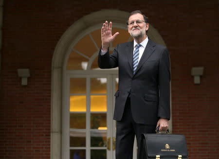 Spanish Prime Minister Mariano Rajoy waves as he arrives for first cabinet meeting after winning a parliamentary confidence vote for a second term ending 10 months of political paralysis that included two inconclusive elections, at the Moncloa Palace in Madrid, November 4, 2016. REUTERS/Sergio Perez