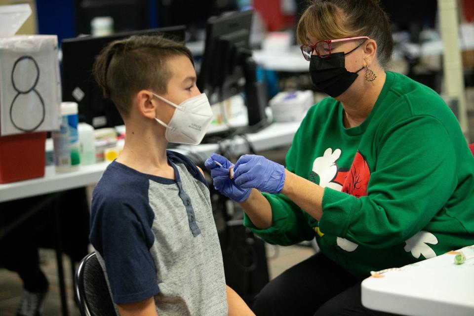 CPOC employee Tamera Huff places a bandage on Aiden Turner, 11, after he calmly received a Pfizer dose at Central Ohio Primary Care in Westervilleon Saturday.
