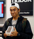 Kent Lee, 20, the first customer in the queue, poses with his new iPhone 7 at an Apple reseller shop in Singapore September 16, 2016. REUTERS/Edgar Su