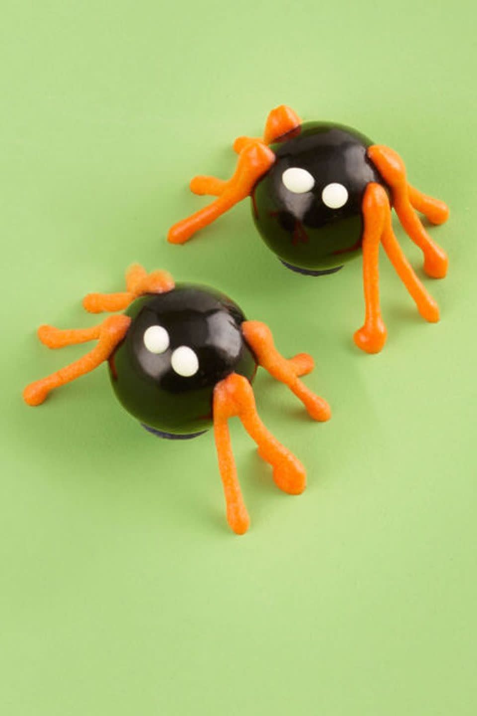 <p>Arrange black candy-coated chocolates or mini gumballs on the cake to create these crawling critters. Using royal icing, pipe on the legs, the eyes, and you're done!</p><p>Get the <strong><a href="https://www.womansday.com/food-recipes/food-drinks/recipes/a11415/chocolate-haunted-forest-cake-recipe-wdy1013/" rel="nofollow noopener" target="_blank" data-ylk="slk:Spooky Spiders recipe;elm:context_link;itc:0;sec:content-canvas" class="link ">Spooky Spiders recipe</a></strong>.</p>