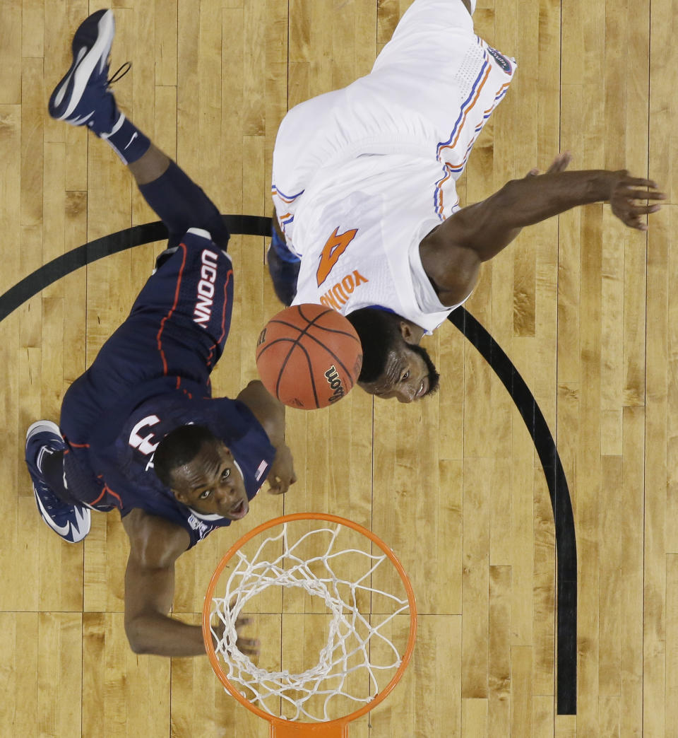 Connecticut guard Terrence Samuel, left, and Florida center Patric Young eye a rebound during the first half of an NCAA Final Four tournament college basketball semifinal game Saturday, April 5, 2014, in Arlington, Texas. (AP Photo/David J. Phillip)