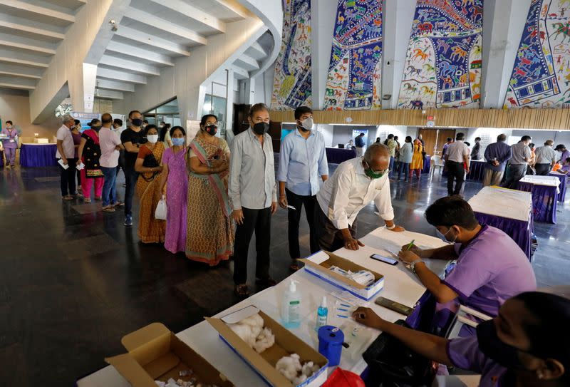 People queue to register their names to get a dose of COVISHIELD, a coronavirus disease (COVID-19) vaccine, in Ahmedabad