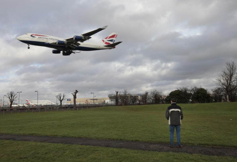 FILE - A man watches as a British Airways plane lands at London's Heathrow Airport, in this Monday Jan. 10, 2011 photo. More pollution is likely to mean bumpier flights for trans-Atlantic travelers, researchers say, predicting increased turbulence over the north Atlantic as carbon dioxide levels rise. (AP Photo/Lefteris Pitarakis, file)