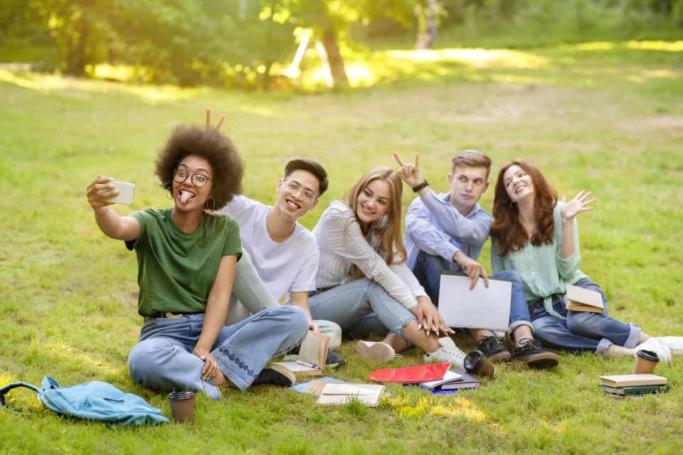 Selfie Fun. Group Of Multiracial Students Fooling While Taking Group Photo Outdoors, Posing On Lawn In Campus, Free Space