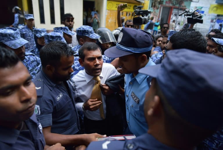 Police try to move former president Mohamed Nasheed (C) during a scuffle as he arrives at a courthouse in Male on February 23, 2015