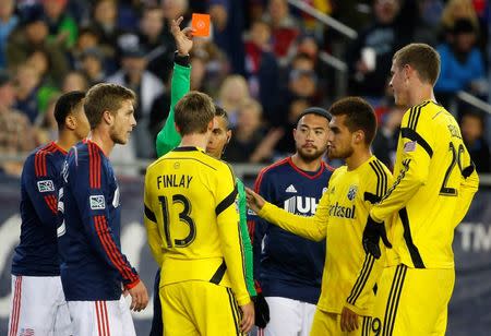 Nov 9, 2014; Foxborough, MA, USA; Referee Armando Villarreal issues a red card to Columbus Crew midfielder Ethan Finlay (13) after he ran into New England Revolution goalkeeper Bobby Shuttleworth during the second half at Gillette Stadium. Mandatory Credit: Winslow Townson-USA TODAY Sports