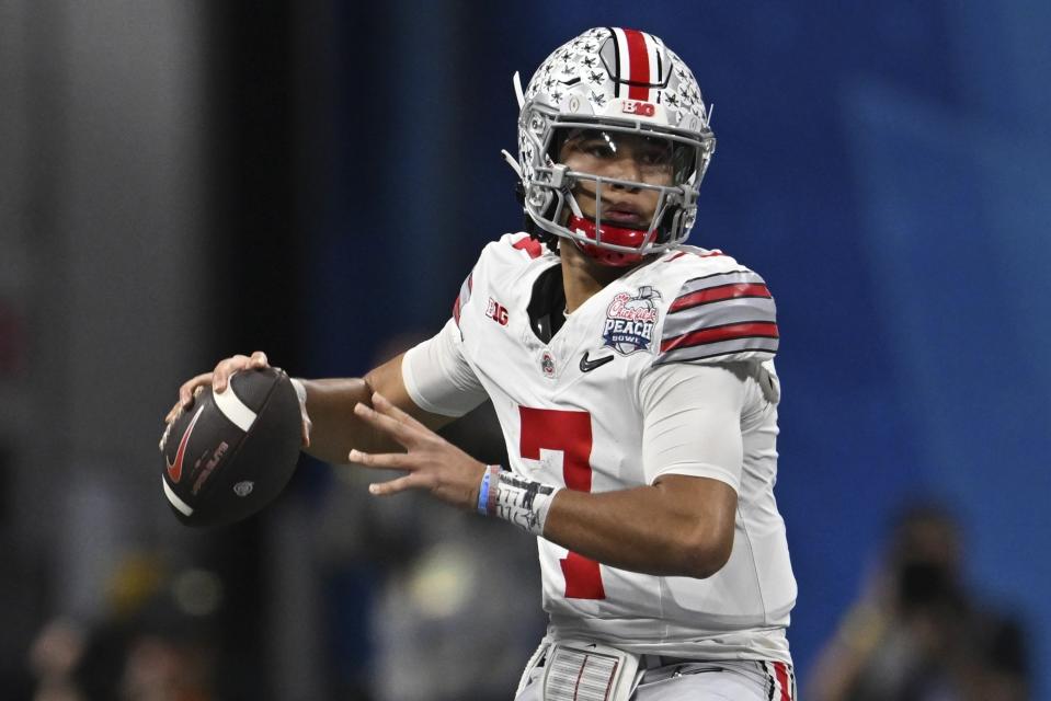 FILE - Ohio State quarterback C.J. Stroud (7) passes against Georgia during the first half of the Peach Bowl NCAA college football semifinal playoff game, Saturday, Dec. 31, 2022, in Atlanta. The Panthers have traded up to acquire the No. 1 overall pick in the draft from the Chicago Bears in exchange for Carolina's No. 9 and No. 61 overall picks in 2023, a first-round pick in 2024, a second-round pick in 2025 and star wide receiver D.J. Moore, two people familiar with the deal said Friday, March 10, 2023, The people spoke to The Associated Press on condition of anonymity because the trade had not been announced. The move allows the Panthers to acquire a potential franchise quarterback, although it remains unclear which player the team prefers. (AP Photo/Danny Karnik, File)