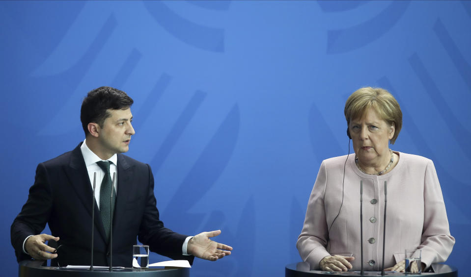 FILE In this file photo taken on Tuesday, June 18, 2019, German Chancellor Angela Merkel, right, and Ukrainian President Volodymyr Zelenskiy, left, attend a joint news conference after a meeting at the chancellery in Berlin, Germany. Ukraine's president sits down Monday, Dec. 9, 2019 for peace talks in Paris with Russian President Vladimir Putin in their first face-to-face meeting, and the stakes could not be higher. More than five years of fighting in eastern Ukraine between government troops and Moscow-backed separatists has killed more than 14,000 people, and a cease-fire has remained elusive. (AP Photo/Markus Schreiber, File)